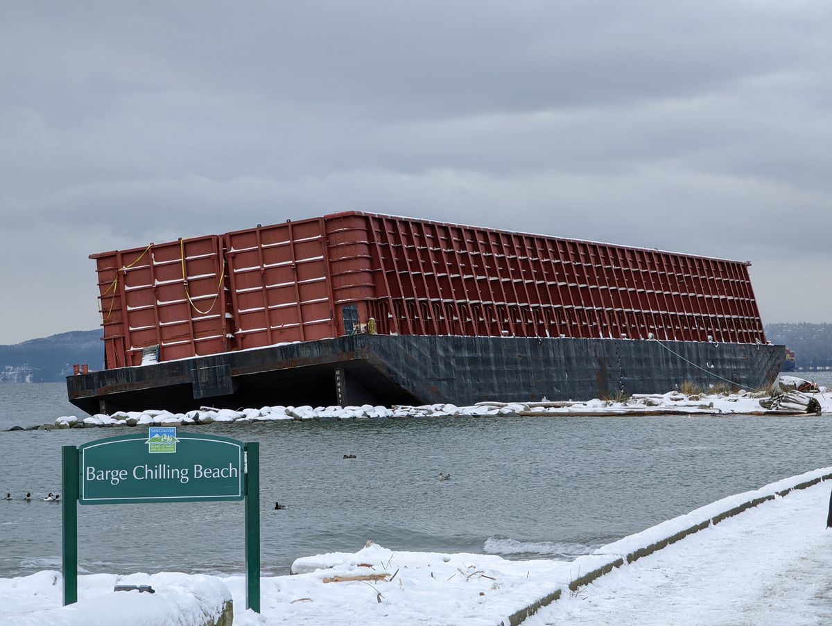 Barge Chilling Beach sign in front of a red barge stranded on the snowy shore